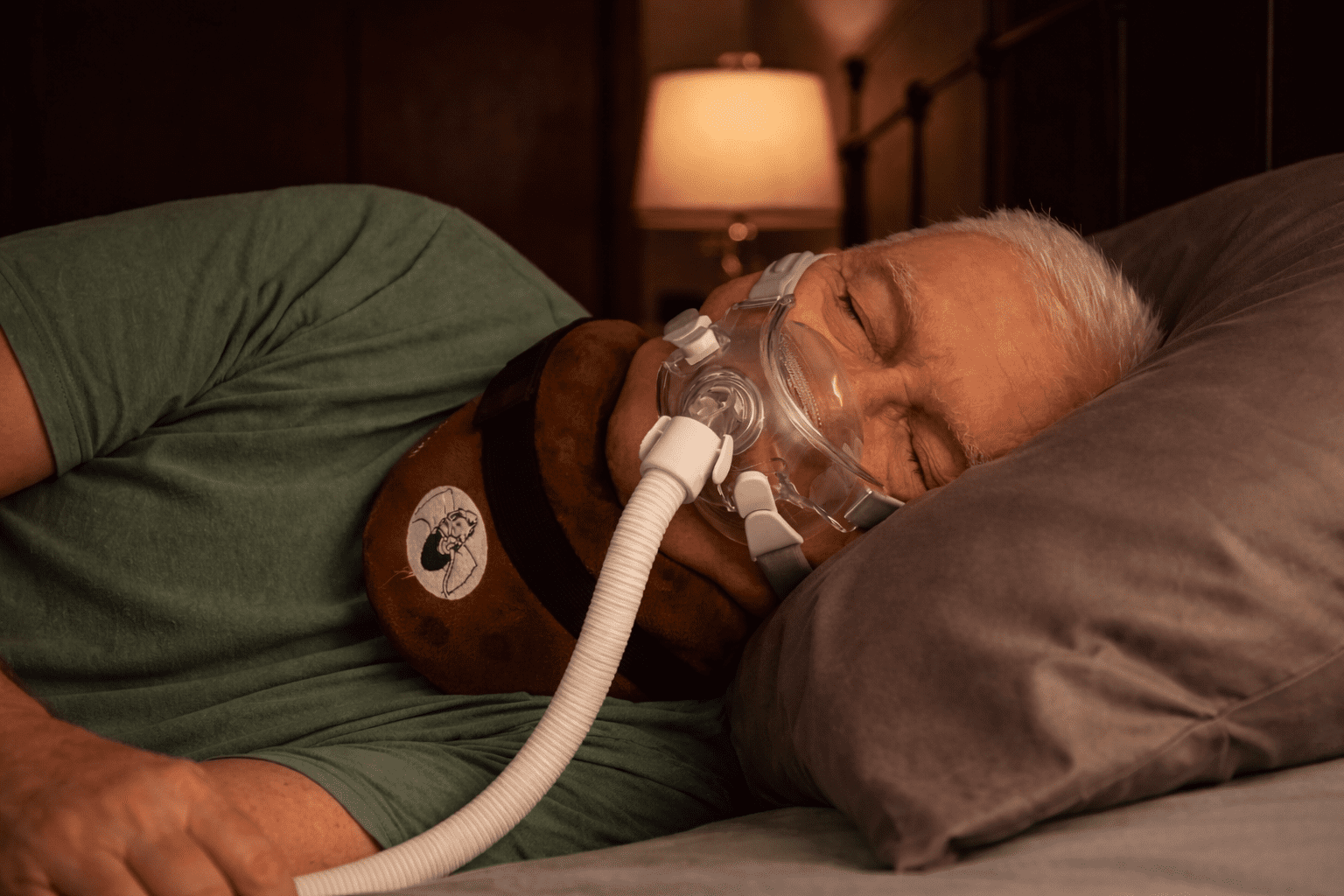 Man sleeping on his side with CPAP mask using neck support cushion to maintain alignment and reduce air leaks